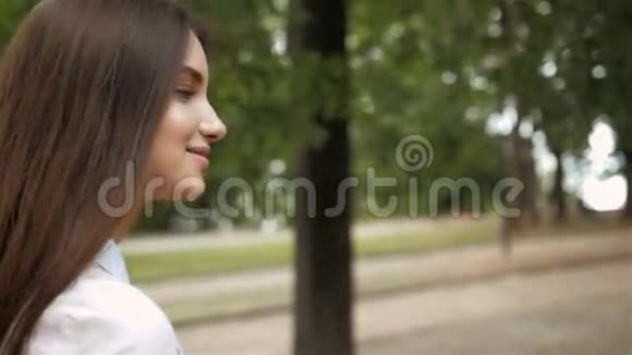 跟我来女孩的概念年轻快乐的学生模特儿微笑着走在公园里视频的预览图