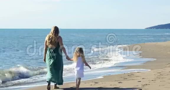 妈妈和女儿在海滩上散步视频的预览图