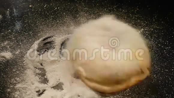 一个带糖粉的甜甜圈落在黑桌上视频的预览图