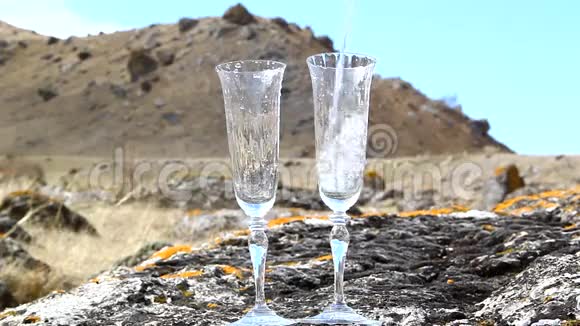 纯透明的水倒在一个贴着天空的玻璃杯里视频的预览图