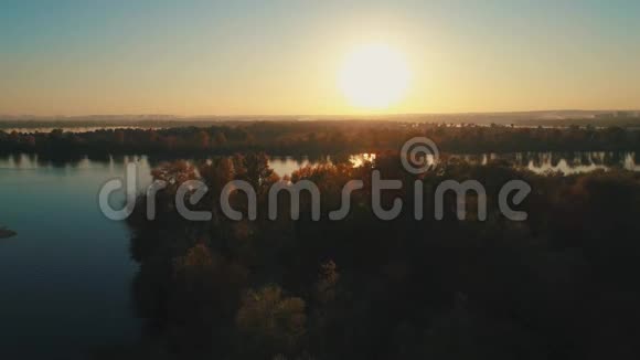 空中无人机镜头日落时分在平静的河流上空飞行视频的预览图