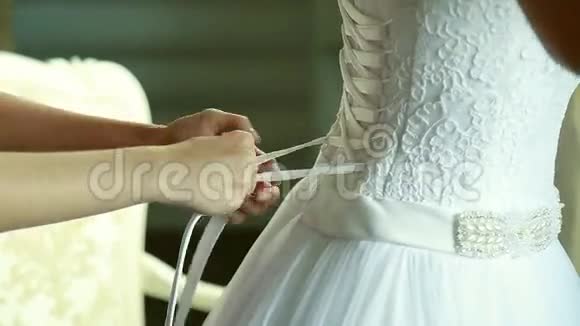 伴娘在新娘婚纱背面做蝴蝶结视频的预览图