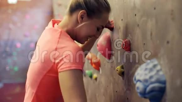 年轻女子在室内攀岩墙上锻炼视频的预览图