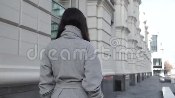 女性沿着城市街道行走视频的预览图