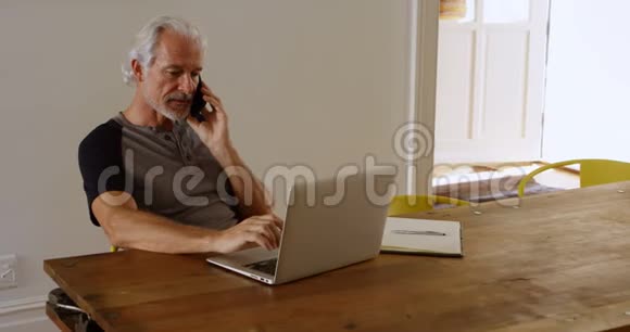 使用4k笔记本电脑时老人在用手机说话视频的预览图