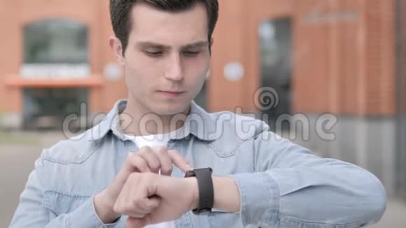 年轻人在户外使用智能手表视频的预览图