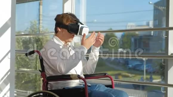 轮椅上的残疾人在窗户上使用虚拟现实头盔视频的预览图