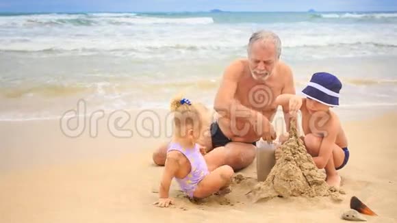 小毛孩爷爷在沙滩上建沙堡视频的预览图