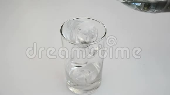 将饮用水倒入白色背景的玻璃杯中视频的预览图