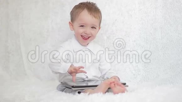 小男孩坐着玩电子平板电脑视频的预览图