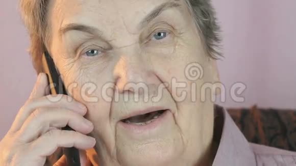 老年妇女微笑着谈论智能手机视频的预览图