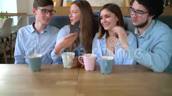 年轻的朋友坐在咖啡馆里喝咖啡在交流中享受乐趣视频的预览图