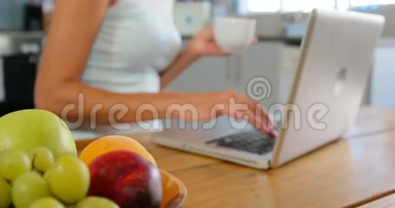 可爱的金发在厨房里用笔记本电脑视频的预览图