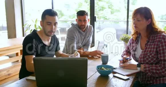 行政人员讨论办公室自助餐厅的笔记本电脑视频的预览图