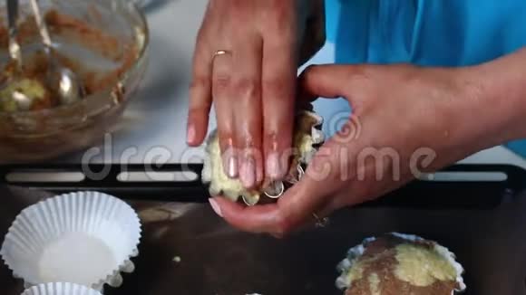 那个女人把面团放进烘焙模具里把面团凝结成烤盘大理石蛋糕的准备视频的预览图