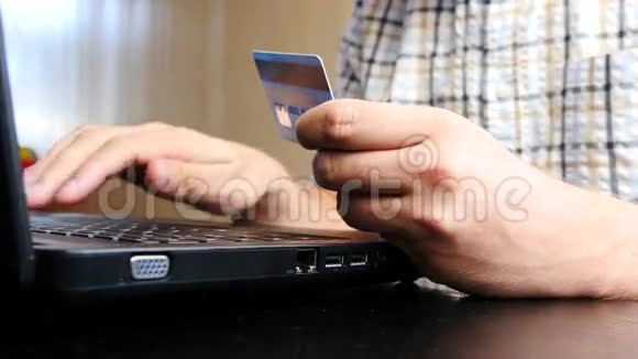 男子使用信用卡和笔记本电脑在线支付视频的预览图