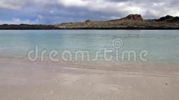 从厄瓜多尔加拉帕戈斯国家公园的中国海帽岛海滩上看到圣地亚哥岛视频的预览图