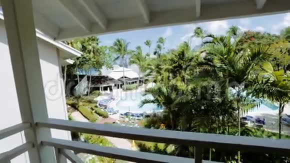 从酒店阳台可以看到美丽的树木和游泳池视频的预览图