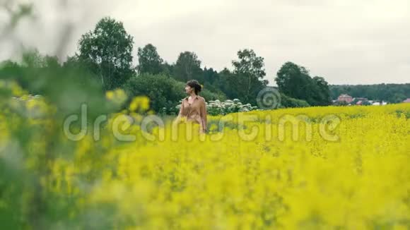 年轻女子走在花田里美丽的风景夏日花田视频的预览图