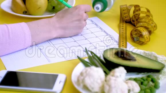 保持一个健身日历健康食品的概念饮食俯视黄色背景视频的预览图