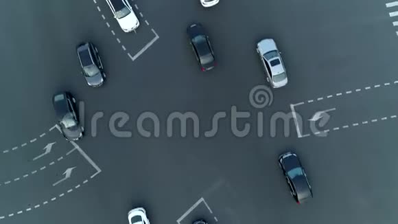 空中无人机在城市的十字路口旋转射击汽车和公共汽车在大道上行驶日落时分视频的预览图