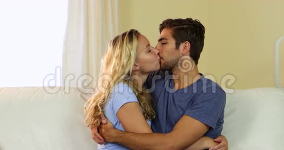 可爱的夫妇在沙发上接吻视频的预览图