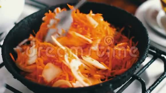 胡萝卜片和洋葱在煎锅里煎蔬菜炖视频的预览图