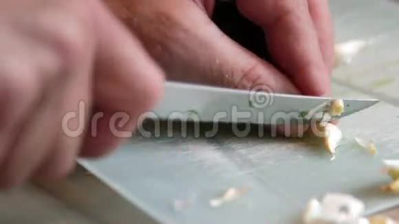 砧板上用刀切碎和剥皮大蒜有机烹饪概念视频的预览图