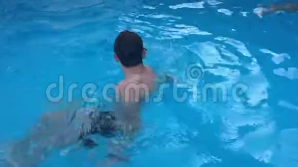 沐浴在池水里孩子们男孩和女孩在游泳池里游泳播放慢动作视频视频的预览图