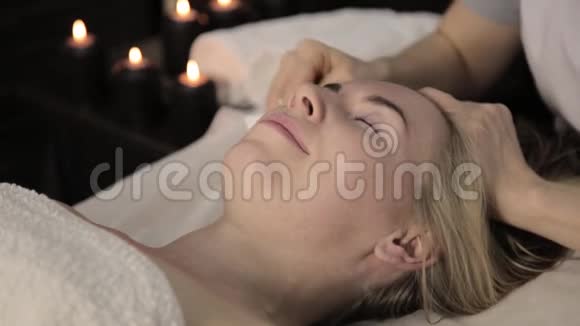 美丽的女人在水疗中心做面部按摩美容院面部皮肤护理视频的预览图