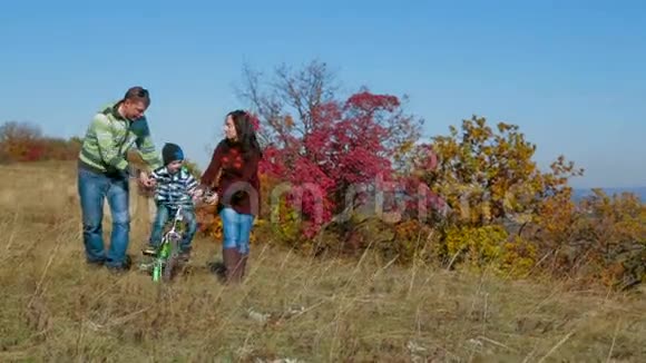 快乐的年轻家庭和孩子在秋天散步视频的预览图