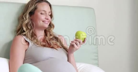 孕妇拿着苹果对着镜头微笑视频的预览图