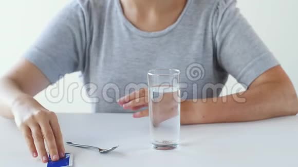 女人在杯水里搅拌药物视频的预览图