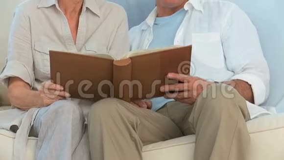 一对退休夫妇在看相册视频的预览图
