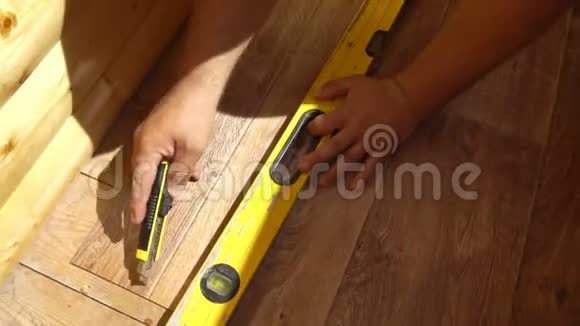 工人用一把实用工具刀把油毡割下来把油毡铺在地板上视频的预览图