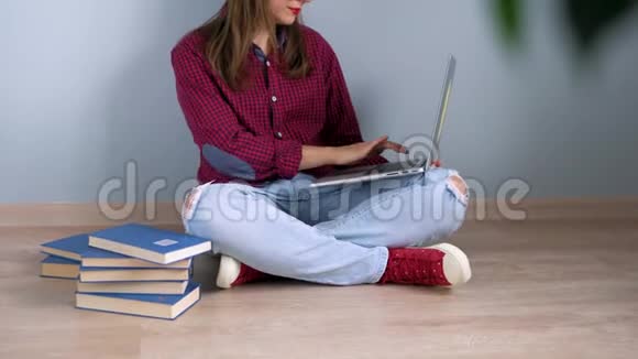漂亮的女孩用笔记本电脑坐在家里的地板上视频的预览图