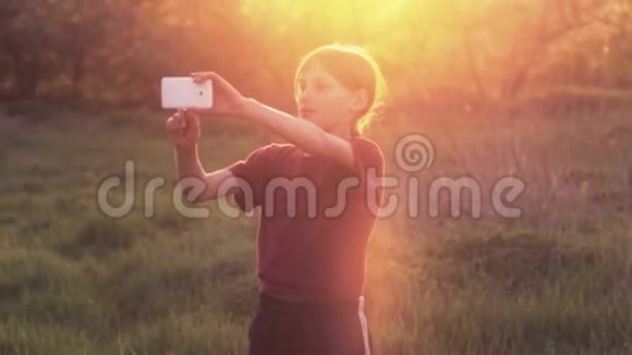 带着电话的白人男孩日落时分带着智能手机的少年有电话照片的男孩日落视频的预览图