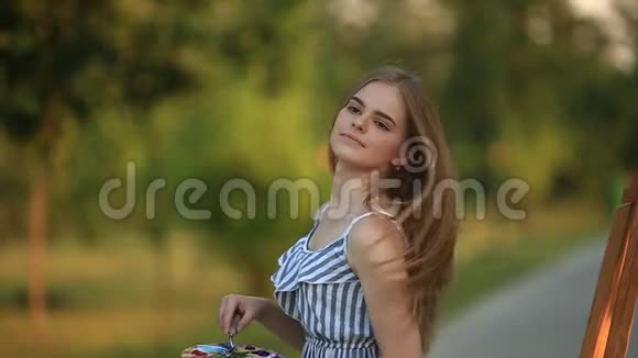 美丽的女孩艺术家站在公园里拿着颜料调色板视频的预览图