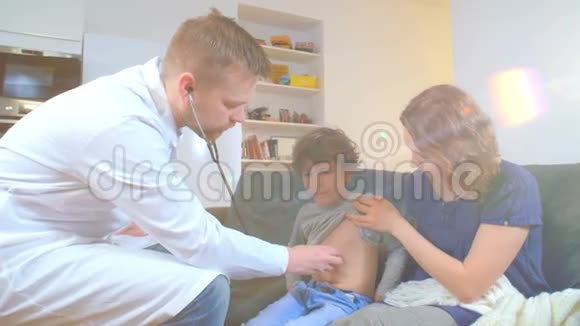 家庭医生找到了生病的男孩和他的母亲他检查一个孩子并把阅读记录在笔记本上视频的预览图