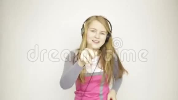 少女听耳机音乐和有趣的舞蹈视频的预览图