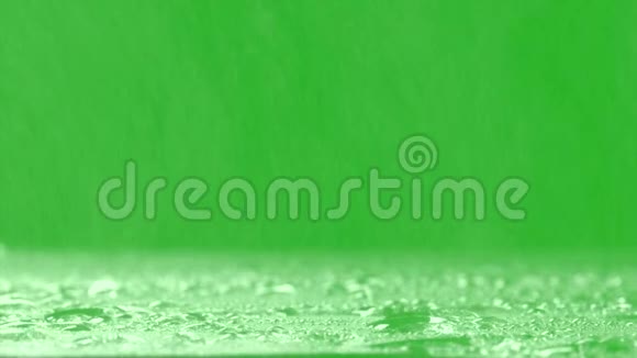 绿色背景下的表面暴雨现实雨和水滴与色度键绿色屏幕背景视频的预览图