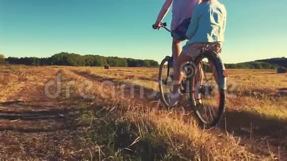 母亲和女儿骑自行车在草地上家庭在大自然中骑自行车家的概念视频的预览图