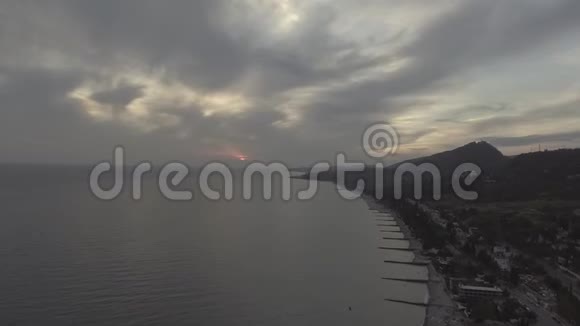 令人叹为观止的海上风光海岸线日落时的青山和多云的天空视频的预览图