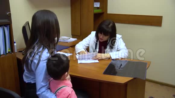 带着孩子去看医生的年轻母亲视频的预览图