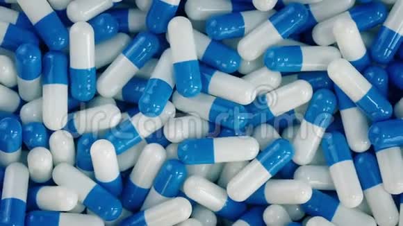 蓝色和白色药物胶囊堆视频的预览图