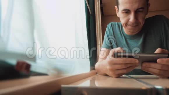 人旅行写智能手机信息社交媒体在信使坐在火车旁的窗口旅行者概念视频的预览图