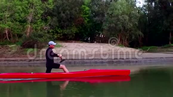 皮艇上的运动划船那个人沿着树林飘下河视频的预览图