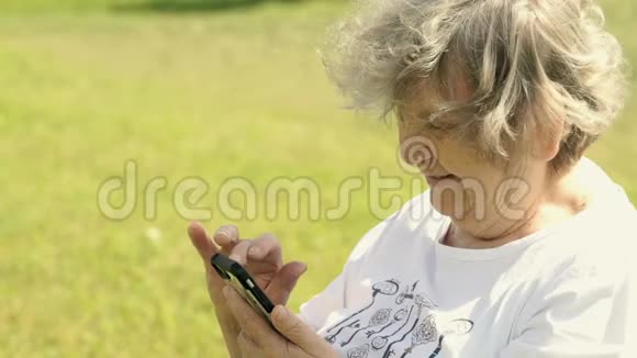 成年老年妇女在户外手持手机视频的预览图