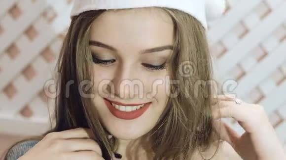 戴着圣诞帽的快乐女孩在后台摆姿势慢慢地视频的预览图