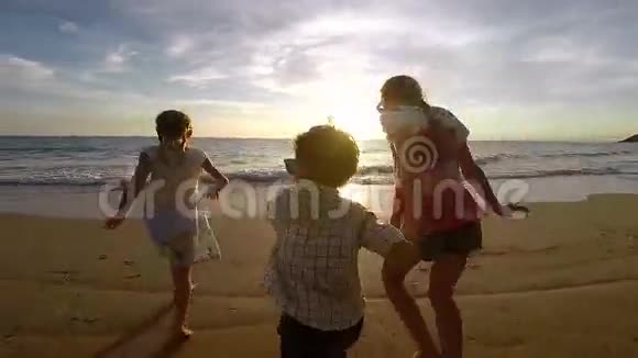 快乐的孩子们在日落时在海滩上玩耍视频的预览图